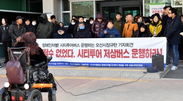 26일 오산시청 후문 앞에서 열린 ‘장애인차별! 시티투어버스 운행하는 오산시장규탄 기자회견’에서 오산수원화성 장애인차별 시티투어 해결을 위한 공동대책위원회 등 참석자들이 “시티투어 저상버스 운행”을 요구하고 있다.전형민기자