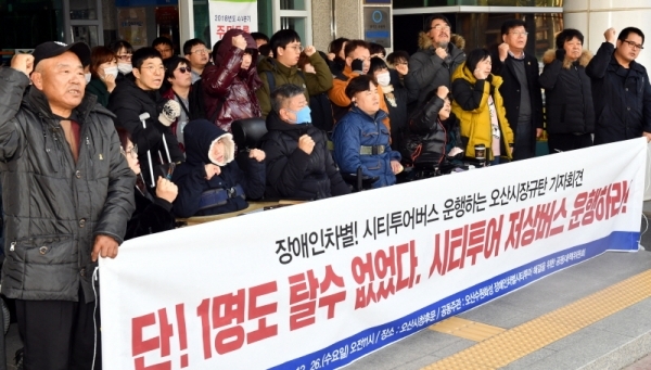 26일 오산시청 후문 앞에서 열린 ‘장애인차별! 시티투어버스 운행하는 오산시장규탄 기자회견’에서 오산수원화성 장애인차별 시티투어 해결을 위한 공동대책위원회 등 참석자들이 “시티투어 저상버스 운행”을 요구하고 있다.전형민기자