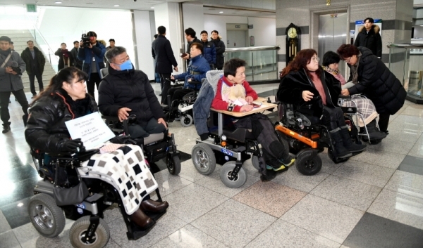 26일 오산시청 후문 앞에서 열린 ‘장애인차별! 시티투어버스 운행하는 오산시장규탄 기자회견’에서 오산수원화성 장애인차별 시티투어 해결을 위한 공동대책위원회 등 참석자 대표들이 오산시장 면담요청서를 전달하기 위해 시장실로 향하고 있다.전형민기자