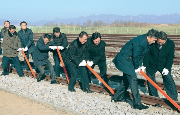 26일 오전 개성 판문역에서 진행된 ‘동·서해선 남북 철도·도로 연결 및 현대화 착공식’에서 남북 관계자들이 궤도 체결식을 하고 있다. 사진공동취재단