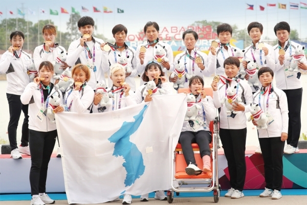 제18회 자카르타-팔렘방 아시안게임 카누 용선 여자 500m에서 금메달을 획득한 남북 단일팀 선수들이 한반도기를 펼치고 기념촬영을 하고 있다. 경기일보 DB