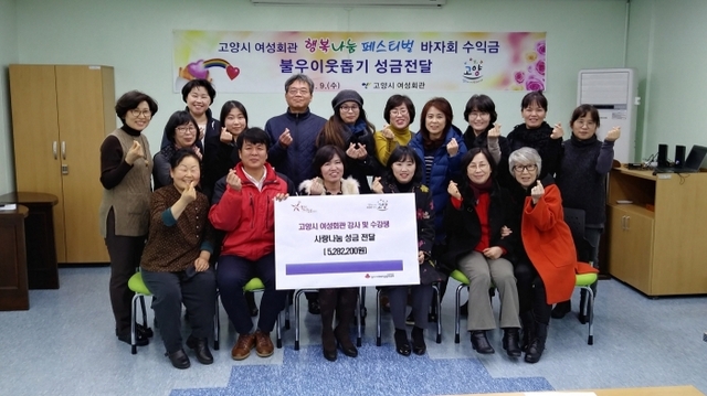 고양시 여성회관 사랑나눔 바자 참여자들이 지난해 12월 ‘2018 여성회관 행복나눔 페스티벌’을 통해 얻은 수익금을 경기북부 사랑의 열매에 기탁하고 기념촬영을 하고 있다. 고양시 제공