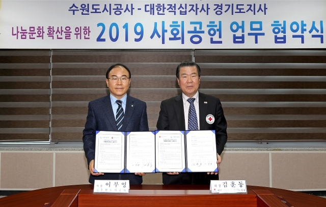 14일 오후 수원시 권선구 더함파크에서 열린 ‘나눔문화 확산을 위한 수원도시공사-대한적십자사 경기도지사 사회공헌 업무 협약식’에서 이부영 수원도시공사 사장과 김훈동 적십자 경기도지사회가 협약서에 서명을 하고 있다.