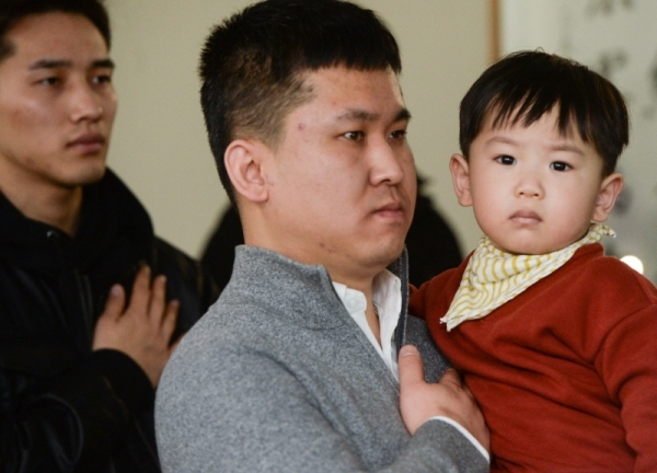 22일 오후 인천 중구 인천출입국외국인청에서 열린 '국적증서 수여식'에서 한 귀화인이 아이를 안고 국민의례를 하고 있다.조주현기자