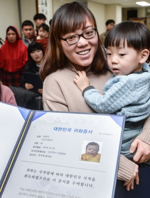 22일 오후 인천 중구 인천출입국외국인청에서 열린 '국적증서 수여식'에서 귀화인 가족들이 대한민국 국적증서를 받고 기뻐하고 있다.조주현기자