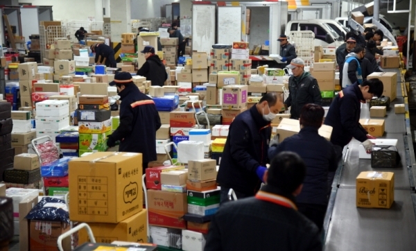 설 연휴를 앞두고 24일 수원시 영통구 수원우편집중국에서 직원들이 산더미처럼 쌓인 택배물을 배달하기 위해 분주히 분류작업을 하고 있다. 수원우편집중국 관계자는 다음주 초 선물용 택배물량이 절정에 달할 것으로 예상된다고 말했다. 김시범기자