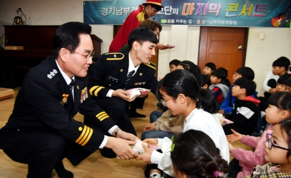 28일 수원시 장안구 정자동 아동복지시설 꿈을 키우는 집에서 열린 ‘경기남부지방경찰청 홍보단 마지막 콘서트’에서 허경렬 경기남부경찰청장과 홍보단원들이 어린이들에게 선물을 나누어 주고 있다. 경기남부지방경찰청 홍보단은 의무경찰 감축·폐지에 따라 지난 23일 해체됐으나 복지시설 원생들과 약속을 지키기 위해 마지막 콘서트를 진행했다.전형민기자