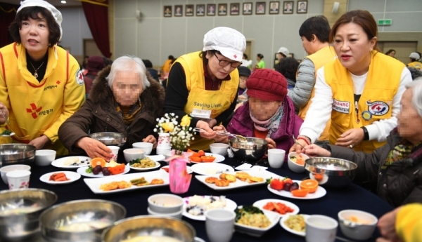 29일 오전 수원시 영통구청 대회의실에서 열린 ‘어르신 孝 떡국잔치’에서 대한적십자사 경기도지사 자원봉사자들이 어르신들에게 떡국을 대접하고 있다. 삼성전기 후원으로 수원시내 소외계층 어르신과 봉사자 150여 명이 모인 가운데 열린 이번 행사에선 다과와 공연, 선물전달 등이 진행됐다.  윤원규 수습기자