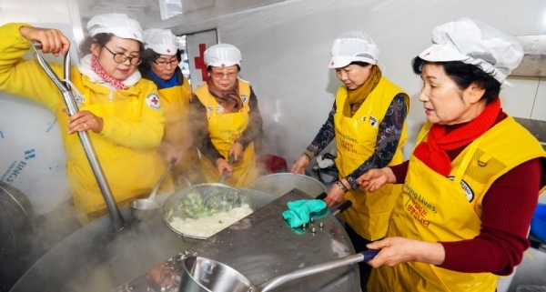 29일 오전 수원시 영통구청 대회의실에서 열린 ‘어르신 孝 떡국잔치’에서 대한적십자사 경기도지사 자원봉사자들이 어르신들에게 떡국을 대접하고 있다. 삼성전기 후원으로 수원시내 소외계층 어르신과 봉사자 150여 명이 모인 가운데 열린 이번 행사에선 다과와 공연, 선물전달 등이 진행됐다.  윤원규 수습기자