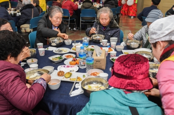 29일 오전 수원시 영통구청 대회의실에서 열린 ‘어르신 孝 떡국잔치’에서 대한적십자사 경기도지사 자원봉사자들이 어르신들에게 떡국을 대접하고 있다. 삼성전기 후원으로 수원시내 소외계층 어르신과 봉사자 150여 명이 모인 가운데 열린 이번 행사에선 다과와 공연, 선물전달 등이 진행됐다.  윤원규 수습기자