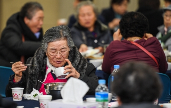 29일 오전 수원시 영통구청 대회의실에서 열린 ‘어르신 孝 떡국잔치’에서 대한적십자사 경기도지사 자원봉사자들이 어르신들에게 떡국을 대접하고 있다. 삼성전기 후원으로 수원시내 소외계층 어르신과 봉사자 150여 명이 모인 가운데 열린 이번 행사에선 다과와 공연, 선물전달 등이 진행됐다.  윤원규 수습기자