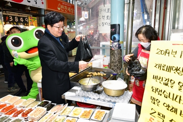 염태영 수원시장이 구매탄시장에서 물건을 사고 있다.