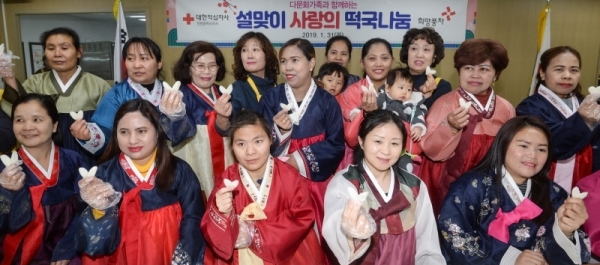 31일 오전 인천 계양구 계산동 대한적십자사 인천광역시지사 북부희망나눔봉사센터에서 열린 '다문화가족과 함께하는 설맞이 사랑의 떡국나눔' 행사에서 다문화가족들이 가래떡 썰기 체험을 한 뒤 기념촬영을 하고 있다.조주현기자