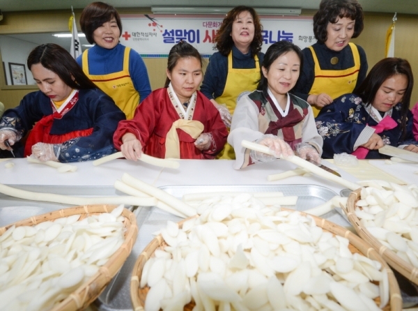 31일 오전 인천 계양구 계산동 대한적십자사 인천광역시지사 북부희망나눔봉사센터에서 열린 '다문화가족과 함께하는 설맞이 사랑의 떡국나눔' 행사에서 다문화가족들이 가래떡 썰기 체험하고 있다.조주현기자