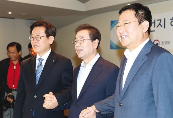 이재명 경기도지사가 지난해 7월 서울 중구 컨퍼런스하우스 달개비에서 열린 ‘수도권 광역자치단체장 간담회’에서 박원순 서울시장, 박남춘 인천시장과 손을 잡고 있다.