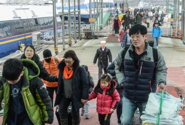 설 연휴 마지막 날인 6일 오전 인천 중구 인천항 연안여객터미널에서 섬 지역 귀경객들이 선물 보따리를 들고 잔교를 빠져나오고 있다.조주현기자