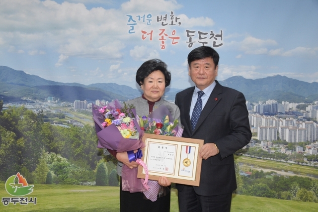 최용덕 동두천시장(사진 오른쪽)과 박성양 1일 명예시장이 위촉장을 들고 사진촬영을 하고 있다.