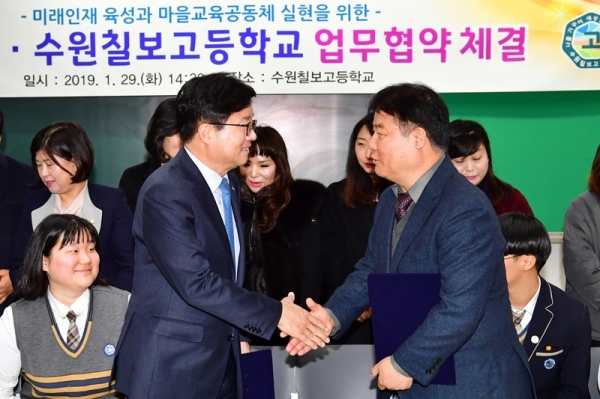 염태영 수원시장(왼쪽)과 김영창 수원칠보고등학교이 1월 29일 학교시설 개방 관련 협약 체결 후 악수하고 있다.