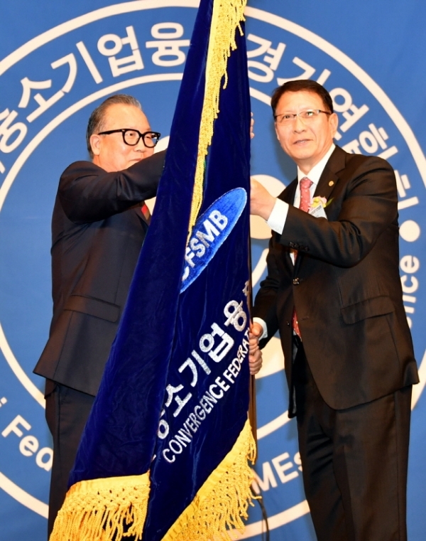 20일 라마다프라자 수원호텔에서 열린  ‘중소기업융합경기연합회 제24차 정기총회 및 제13ㆍ14대 연합회장 이ㆍ취임식’에서 제13대 한희준 연합회장이 제14대 전경표 연합회장에게 연합회기를 전달 하고 있다.전형민기자