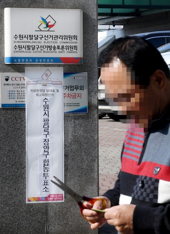 24일 자유한국당 전당대회 사전투표가 전국 시,군,구 투표소에서 진행됐다. 수원시 팔달구, 장안구 합동 투표소앞을 시민이 지나가고 있다. 윤원규 수습기자