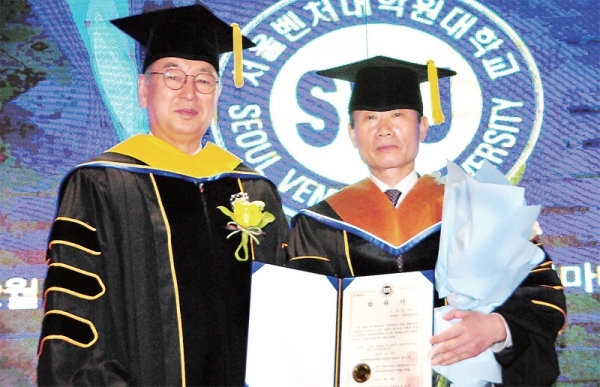 김종억 회장(오른쪽)이 박호군 서울벤처 대학원 대학교 총장으로부터 경영학 박사학위를 받고 있다.