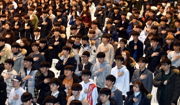 25일 아주대학교 체육관에서 열린 아주대학교 2019학년도 입학식에서 신입생들이 국민의례를 하고 있다.전형민기자