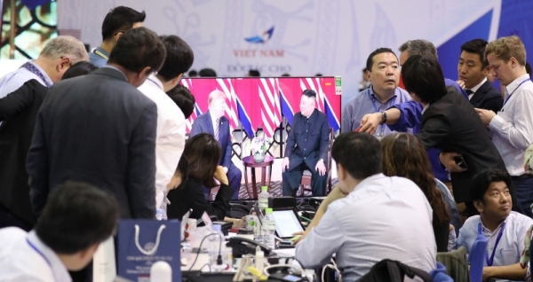 27일 베트남 하노이 베트남-소련 우전노동문화궁전에 마련된 국제미디어센터에서 백악관 출입 기자들이 스크린을 통해 중계되는 도널드 트럼프 미국 대통령과 김정은 북한 국무위원장의 만남을 지켜보고 있다. 연합뉴스