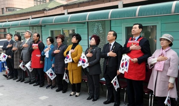 '녹색복지회 20주년 기념식 및 3.1절 100주년 축하행사'가 열린 28일 수원시 장안구 송죽동 복지회 마당에서 김훈동 대한적십자사 경기도지사 회장, 이지현 녹색복지회 회장, 자유한국당 이창성 수원 장안구당협위원장, 최수아 수원시여성단체협의회장, 김준혁 한신대 교수 등 내빈들이 국민의례를 하고 있다. 녹색복지회는 지난 20년간 지역 노인들을 위해 무료급식 활동을 펼쳐온 봉사단체다. 김시범기자