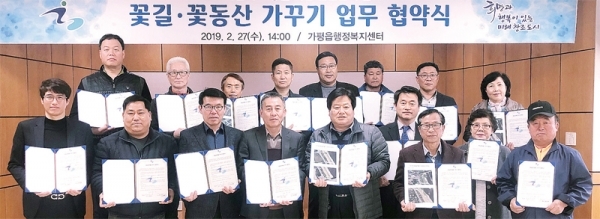 가평읍행정복지센터에서 열린 꽃길ㆍ꽃동산 가꾸기 업무 협약식에 참석한 지역내 기관ㆍ단체 관계자들이 협약서를 들어보이고 있다.