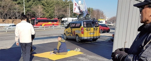 지난 8일 오전 용인의 한 공사장 입구에서 한국노총 소속 노조원 한 명이 돗자리를 깔고 앉아 자재 운반차량이 들어 오는것을 막으며 불법체류자 단속 및 내국인 고용을 촉구하는 내용의 집회를 열고 있다. 독자 제공