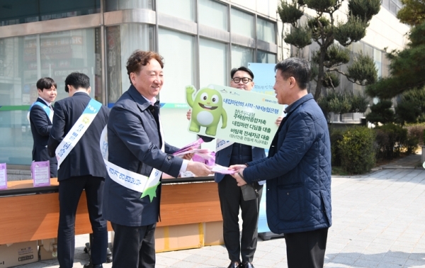 권준학 NH농협은행 경기영업본부장이 14일 수원시청역 사거리에서 시민에게 미세먼지 마스크와 금융상품 안내장을 전달하고 있다. 경기농협 제공