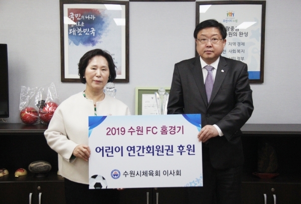 20일 2019시즌 수원FC 연간회원권 전달식에 참석한 배민한(오른쪽) 수원시체육회 사무국장과 김복희 수원지역아동센터연합회 회장이 기념촬영을 하고 있다.수원시체육회 제공