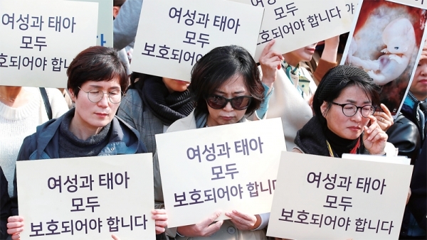낙태죄폐지반대전국민행동 단체 회원들이 11일 헌법재판소 앞에서 낙태죄 합헌을 주장하는 내용의 손팻말을 들고 있다. 연합뉴스
