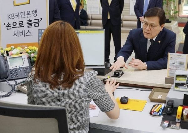최종구 금융위원장이 KB국민은행이 출시한 정맥인증 출금서비스 시연을 하고 있다.