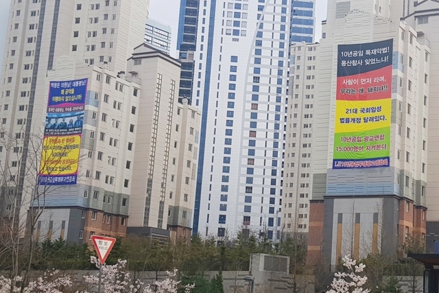 15일 수원 광교센트럴타운 아파트 벽면에 ‘10년 공공임대주택 분양가’와 관련, 입주민들이 국토부와 LH 등에 호소하는 현수막이 붙어 있다. 이연우기자