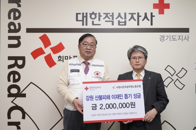 좌측 적십자 경기지사 최석환 사무처장이 우측 수원시민주공무원노동조합 김해영 위원장에게 성금을 전달받고 있다