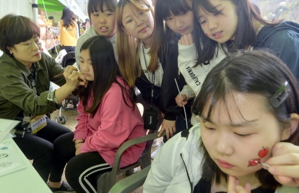 페이스페인팅 부스에서 참가자들이 페이스페인팅 체험을 하고 있다.조주현기자