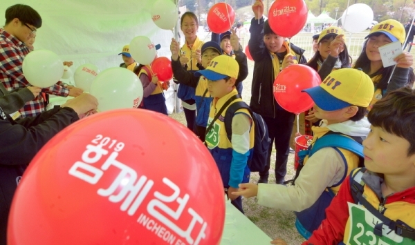 풍선 나눔 부스에서 참가자들이 '함께 걷자 인천 페스타'라고 쓰인 풍선을 받고 있다. 조주현 기자