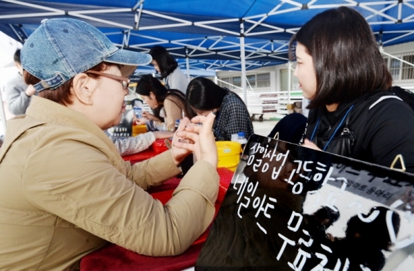 3.1 운동 및 대한민국 임시정부수립 100주년 기념으로 21일 수원 종합운동장에서 열린 '제17회 경기마라톤대회'에서 삼일상업고등학교가 운영하는 네일하트 무료체험 부스에 대회 참가자들이 모여 네일아트를 받고 있다. 윤원규 수습기자
