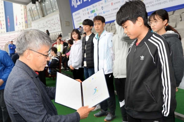 3.1 운동 및 대한민국 임시정부수립 100주년 기념으로 21일 수원 종합운동장에서 열린 '제17회 경기마라톤대회'에서 최종식 기획이사가 체육 유망주학생들에게 상장과 장학금을 수여하고 있다. 윤원규 수습기자