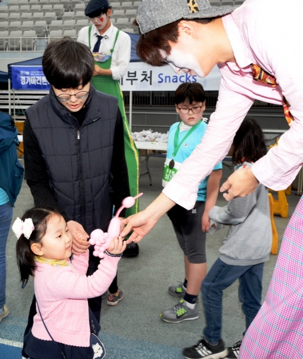 3.1 운동 및 대한민국 임시정부수립 100주년 기념으로 21일 수원 종합운동장에서 열린 '제17회 경기마라톤대회'에서 키다리 풍선 피에로가 아이에게 풍선강아지를 만들어주고 있다. 윤원규 수습기자