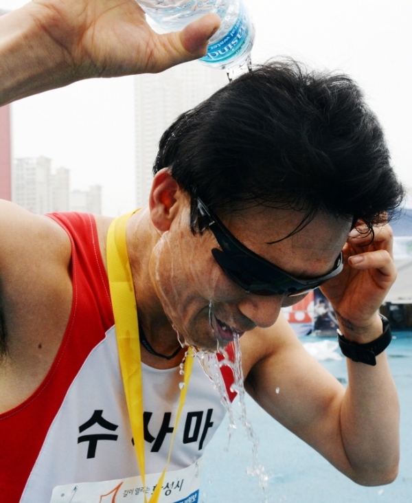 3.1 운동 및 대한민국 임시정부수립 100주년 기념으로 21일 수원 종합운동장에서 열린 '제17회 경기마라톤대회'에서 풀코스를 완주한 참가자들이 물로 머리를 적시며 열을 식히고 있다. 윤원규 수습기자
