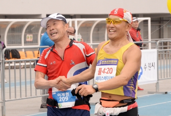 3.1 운동 및 대한민국 임시정부수립 100주년 기념으로 21일 수원 종합운동장에서 열린 '제17회 경기마라톤대회'에서 풀코스 4시간 20분대 페이스메이커와 참가자가 함께 손을 맞잡고 결승선을 통과하고 있다. 윤원규 수습기자