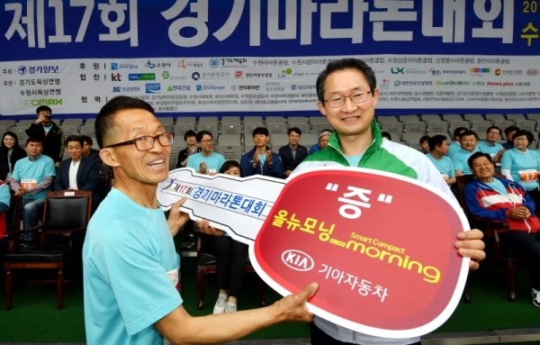 21일 수원 종합운동장에서 열린 제17회 경기마라톤대회에서  신항철 대표이사 사장, 김희겸 경기도 행정1부지사가 기아자동차 경품 당첨자에 대한 시상 후 기념촬영을 하고 있다. 전형민기자