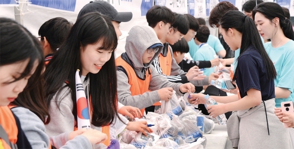 ▲ 21일 수원 종합운동장에서 열린 ‘제17회 경기마라톤대회’에서 자원봉사자 학생들이 레이스를 마치고 골인한 참가자들에게 물과 간식을 나눠주고 있다. 특별취재반