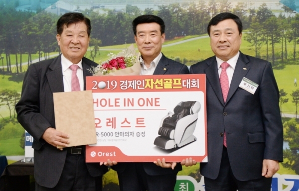 2019 경제인 자선골프 행사 만찬회 경품행사에서 경기일보 신항철 대표이사 사장과 유기덕 오레스트 회장이 홀인원을 한 황근순씨에게 경품을 수여하고 있다. 윤원규 수습기자