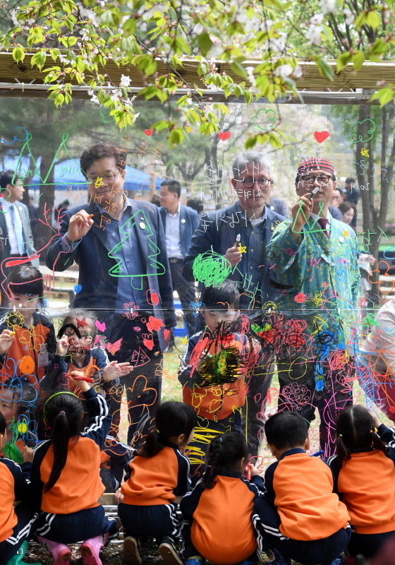24일 수원 국립산림과학원에서 열린 숲속 공연 토크콘서트에서 염태영 수원시장 등이 '수원시민과 함께하는 행복한 도시 숲 이야기'란 주제로 토크콘서트를 마친 후 투명 아크릴판에 자연을 그리고 있다. 김시범기자