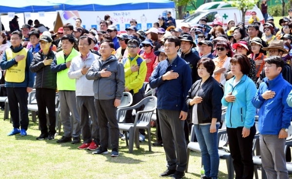 27일 오전 하남시청과 유니온파크 일원에서 열린  '백제가 꿈꾼 제8회 하남 위례길 걷기대회'에서 김상호 하남시장, 이현재 국회의원, 방미숙 하남시의회의장, 경기일보 최성일 상무이사, 김학래 하남위례길사람들 대표 등 내빈과 4천여 명의 참가자들이 국민의례를 하고 있다. 김시범기자