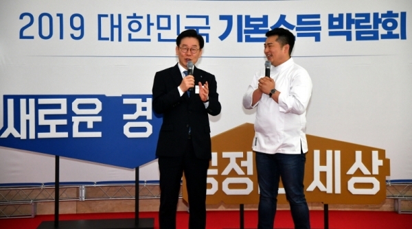 29일 수원컨벤션센터에서 열린 ‘2019 대한민국 기본소득 박람회’ 오프닝 포토타임에서 이재명 경기도지사가 기본소득 박람회 홍보대사 이원일 쉐프와 포토월 앞에서 대화를 나누고 있다.전형민기자