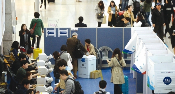 2016년 4월 10일 4·13총선 사전투표 이틀째인 9일 오전 인천시 영종도 인천공항 3층 출국장에 설치된 사전투표소에서 해외 여행객들이 출국에 앞서 투표를 하고 있다.